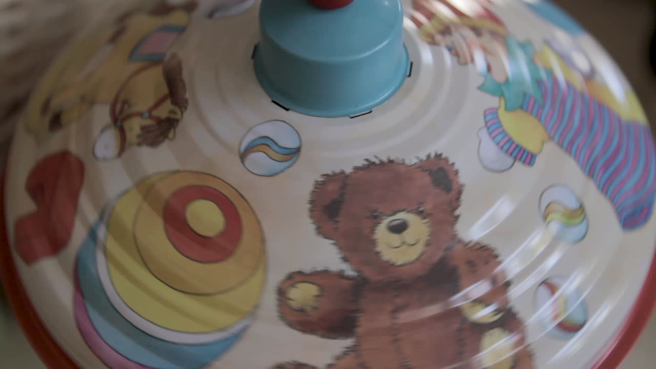 A colorful spinning toy top in motion creating a blur of vibrant patterns and colors