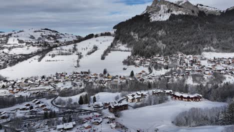 Tilt-down-on-ski-station-in-winter-with-snow-and-mountain,-Bernex,-French-Alps