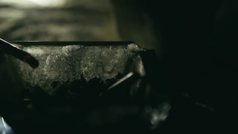cigarette smouldering in glass ashtray in dark moody light close-up