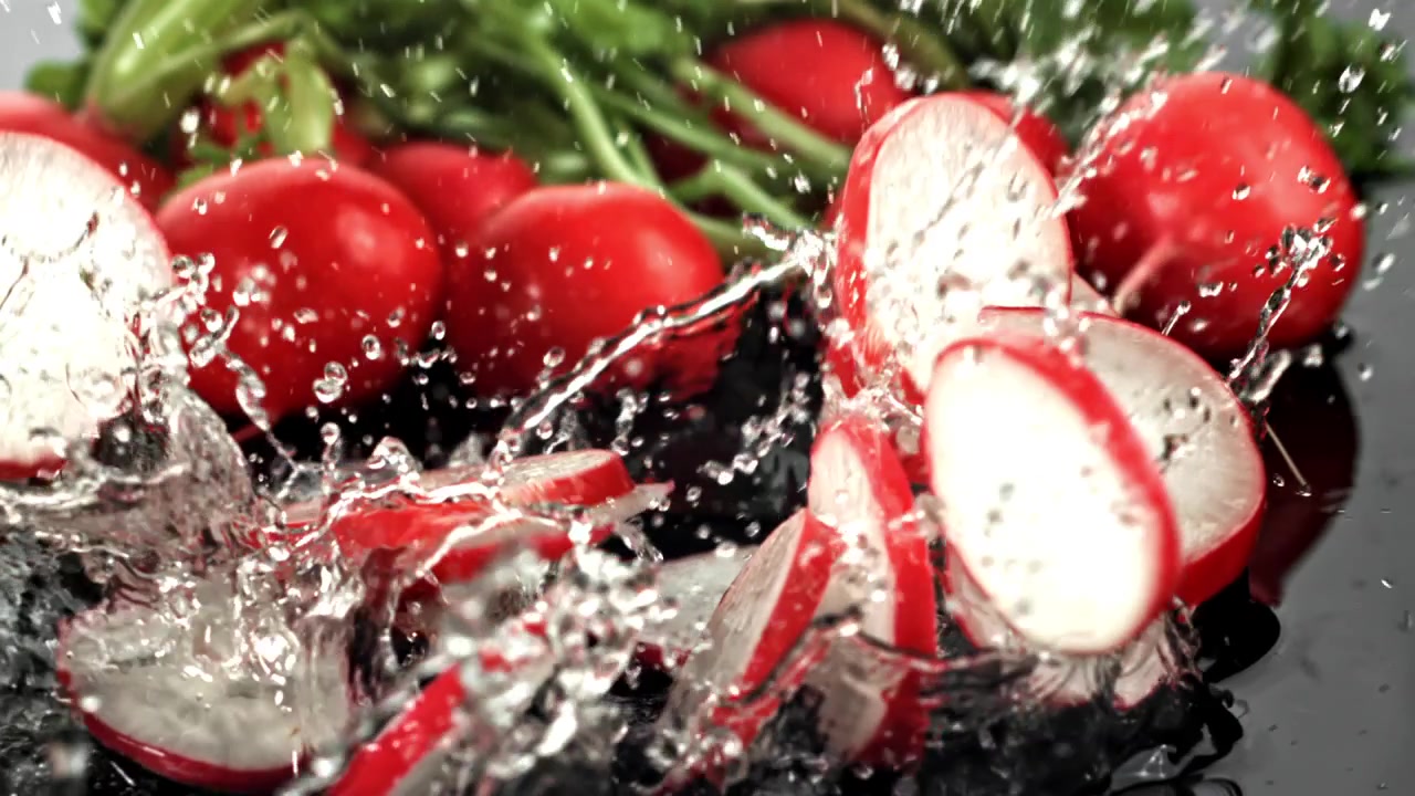 Slow Motion of Fresh Radish Slices Splashing into Water