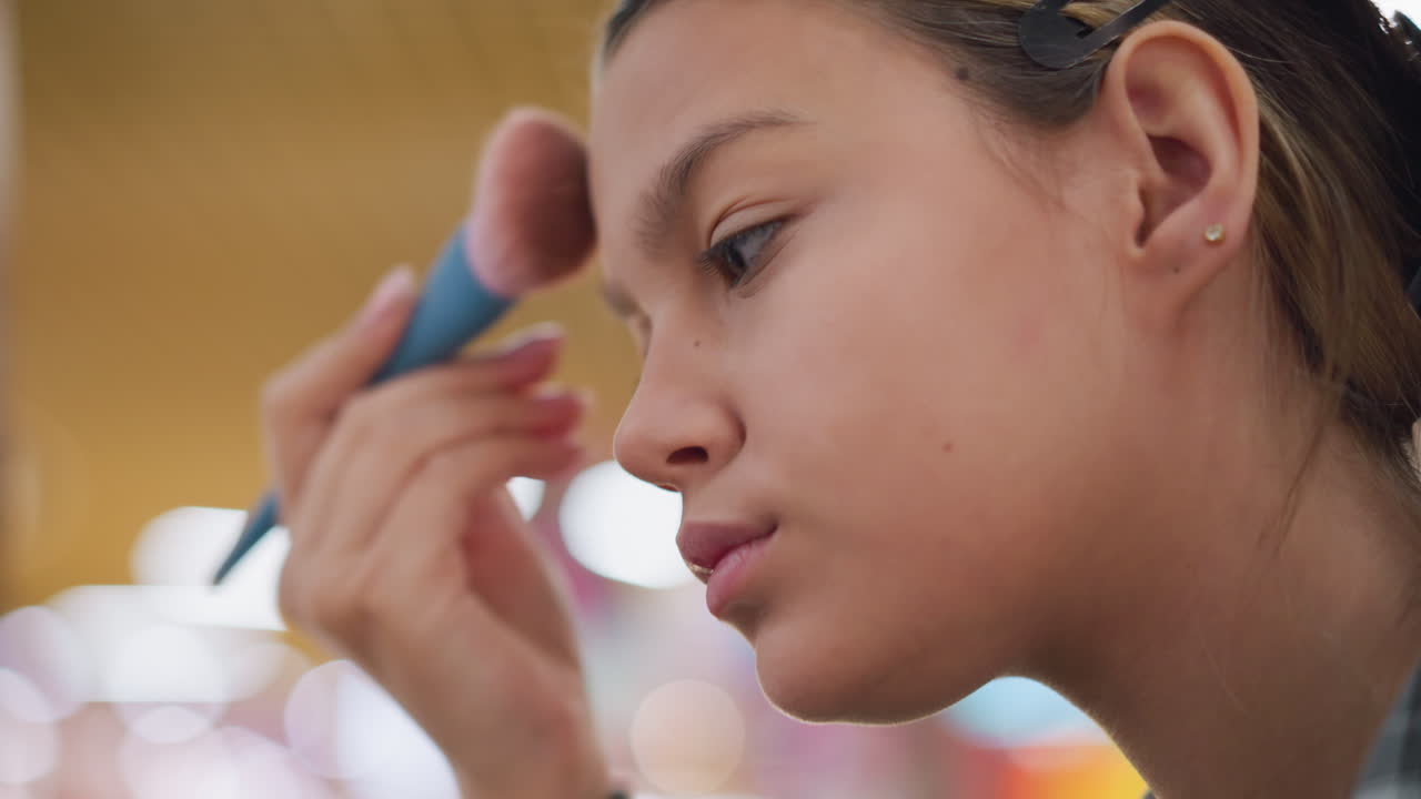 primer plano de una mujer aplicando maquillaje a la cara con un pincel suave, centrándose en la rutina de belleza y el cuidado personal, toque suave mientras mejora su tez en un fondo vibrante con iluminación suave