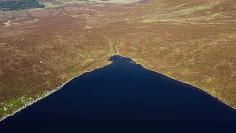 aerial shot of lough ouler, wicklow’s iconic heart shaped mountain lake on a sunny day