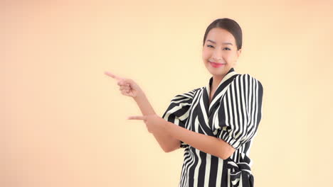 portrait of young asian businesswoman pointing with fingers on something on left static full frame slow motion