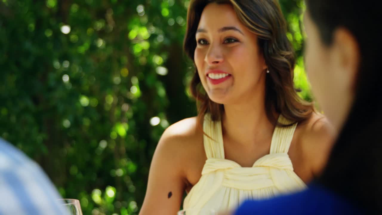 행복 한 여자 가 점심 을 먹으면서 부부 와 상호 작용 하고 있다