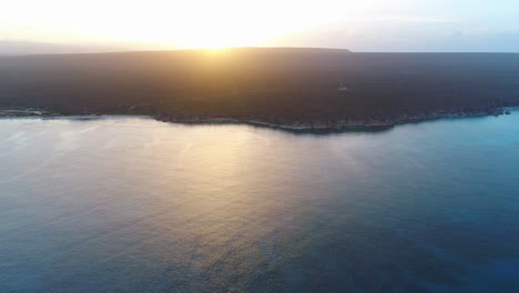 bahía de águilas vista desde el océano, puesta de sol en segundo plano