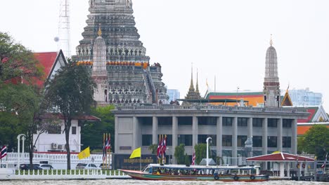 un barco se mueve más allá del templo de wat arun