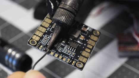 technician soldering circuit board at workbench, closeup soldering iron diy electronic repair