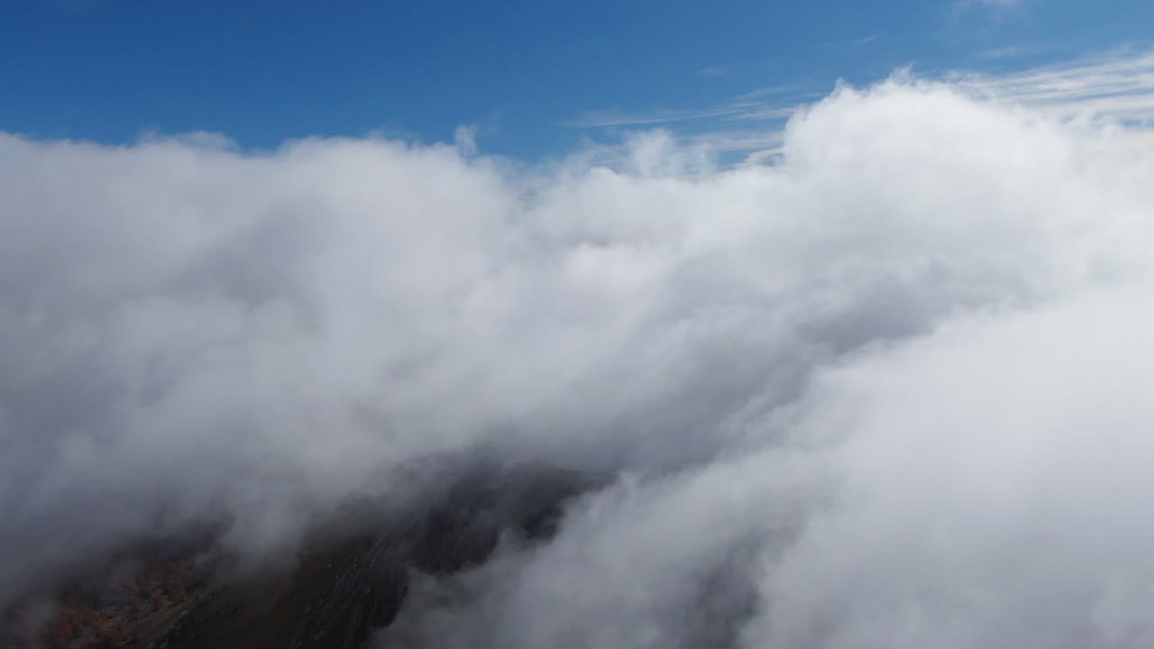 Fog moving across the top of the mountain. A cold autumn morning on top of a mountain captured by a drone.