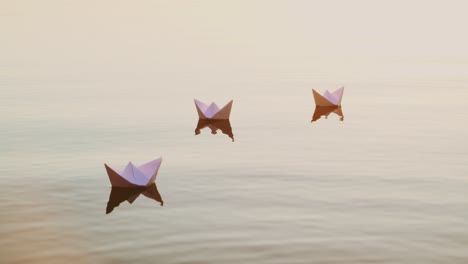 three white paper ships floating in the river at sunset. small childish paper boats swim in the lake with their reflection in the calm water.