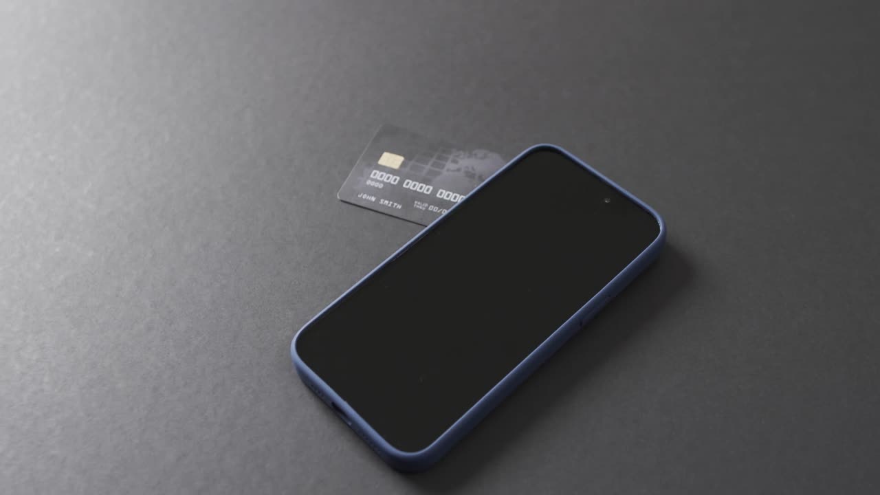 Video of smartphone with blank screen, boxes and credit card with copy space on grey background
