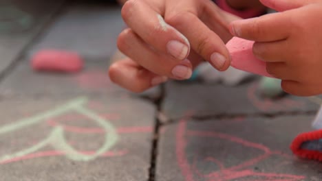 a child with his mother paints on the ground in front of the house