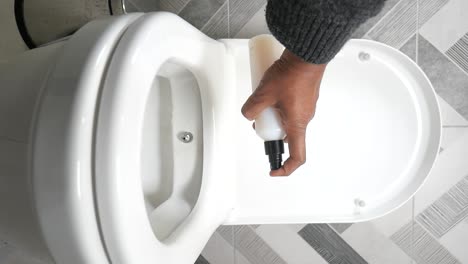 cleaning a toilet with spray bottle