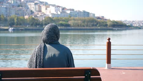 woman in hijab sitting by the river