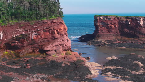 aerial drone shot traveling around a cliffside with red rocks