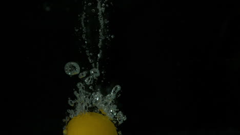 Lemon-plunging-into-water-on-black-background