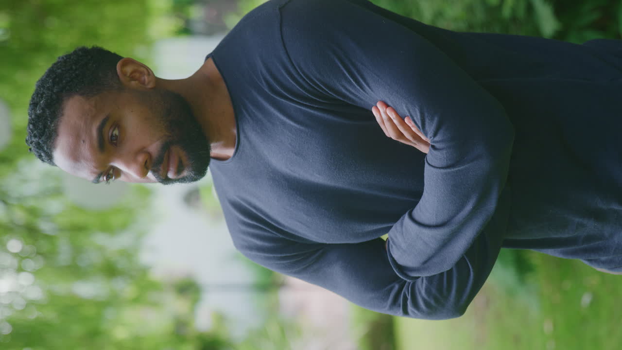 Vertical Video Portrait Of Relaxed Smiling Man Standing In Garden At Home After Retirement