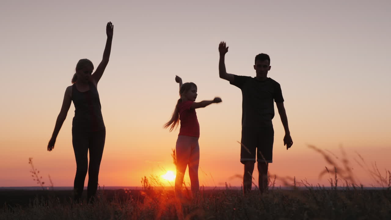familia joven con un niño haciendo ejercicios en un hermoso lugar al atardecer