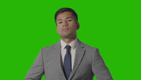 Portrait-Of-Serious-Businessman-In-Suit-Against-Green-Screen-Looking-At-Camera-1