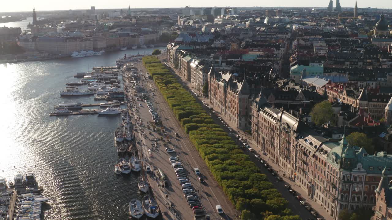 Strandv&auml;gen and Strandkajen, Stockholm during sunny evening with old apartment buildings, traffic, boats and skyline visible