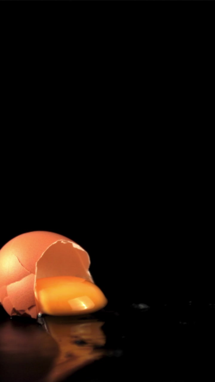 Egg Breaking in Slow Motion on Black Background