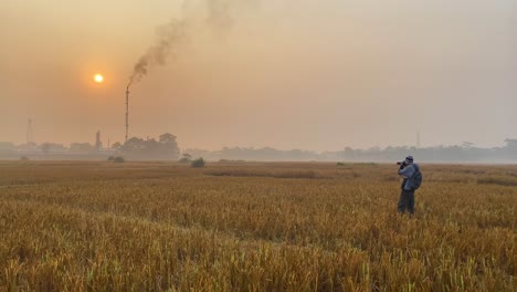 wide shot of photographer documenting pollution by industry gas plant area