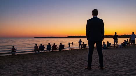 a solemn moment by the shore: a man observing the sunset as a group enjoys a peaceful evening by the water