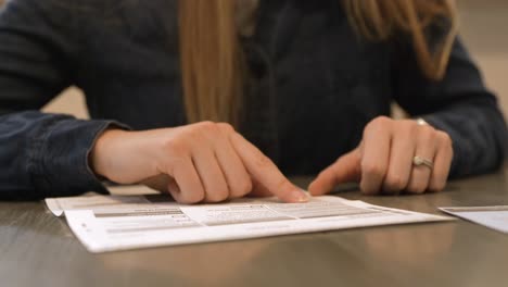 mujer leyendo los nombres de las personas que se postulan para un cargo local en una boleta por correo