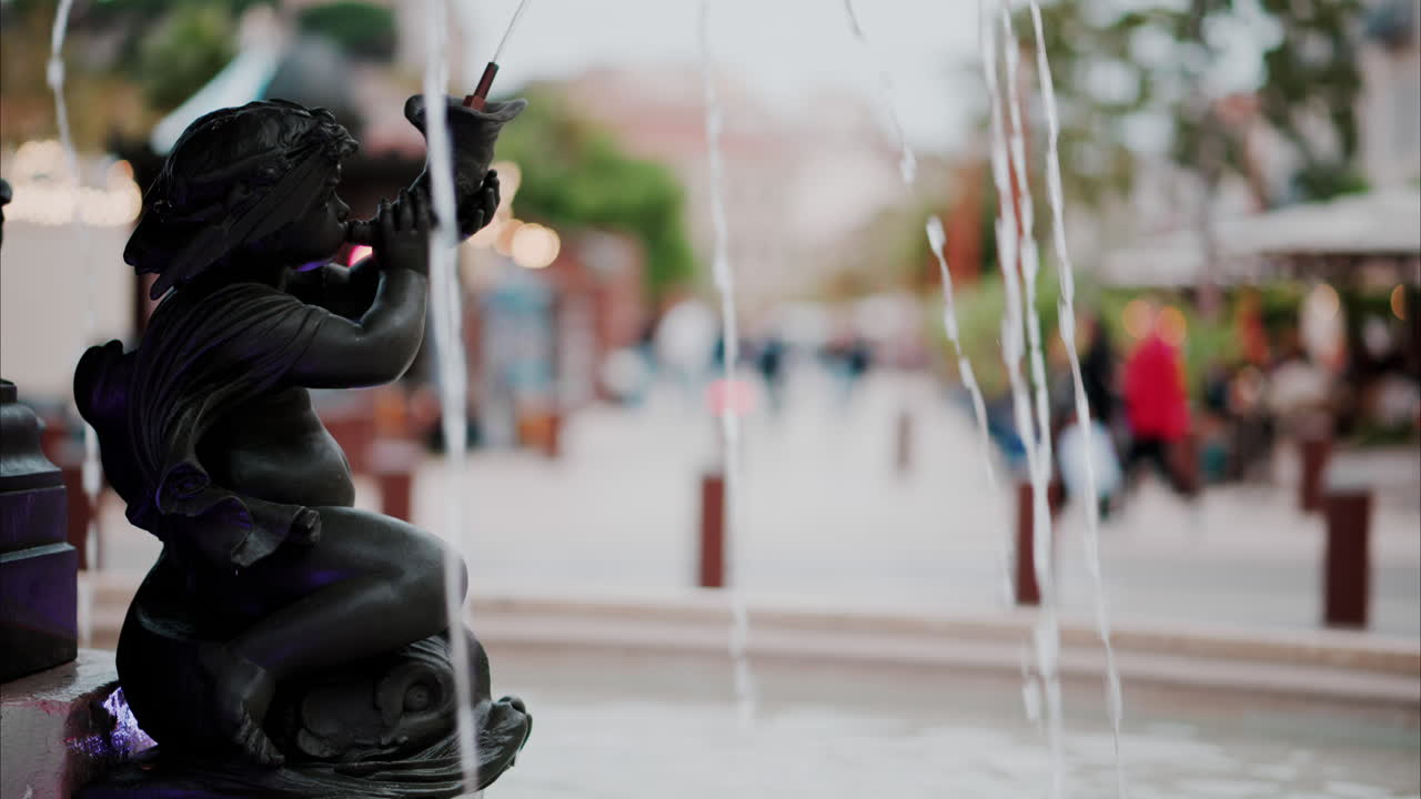 Close up of a water pouring in a fountain with a blurry background in Cannes, France