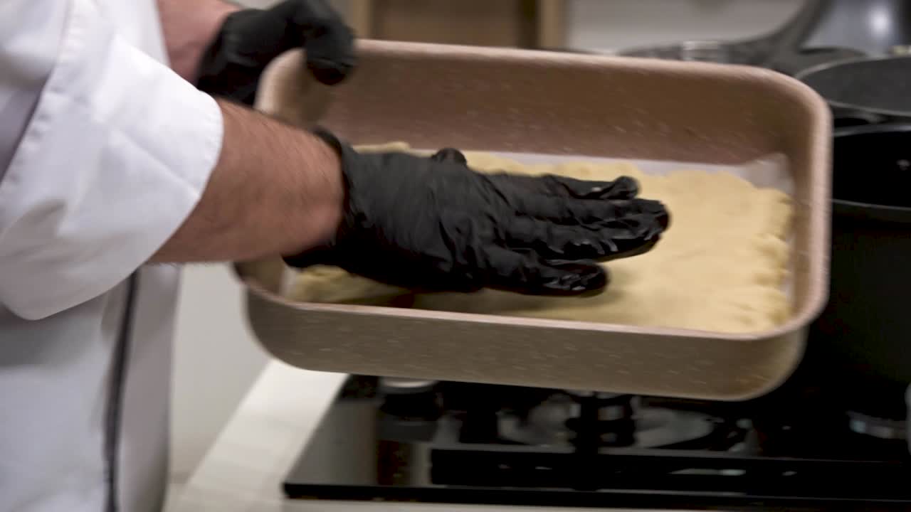 A skilled chef expertly prepares pastry dough in a contemporary kitchen, showcasing techniques for achieving the perfect consistency. Timing and precision are essential in this culinary process