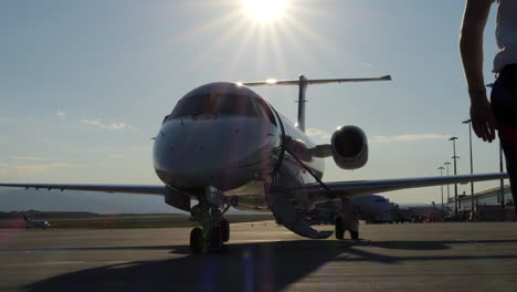 piloto camina hacia su avión en la rampa del aeropuerto slomo