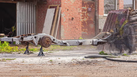 Man-Sandblasting-Vehicle-Chassis-To-Remove-Rust-At-The-Garage