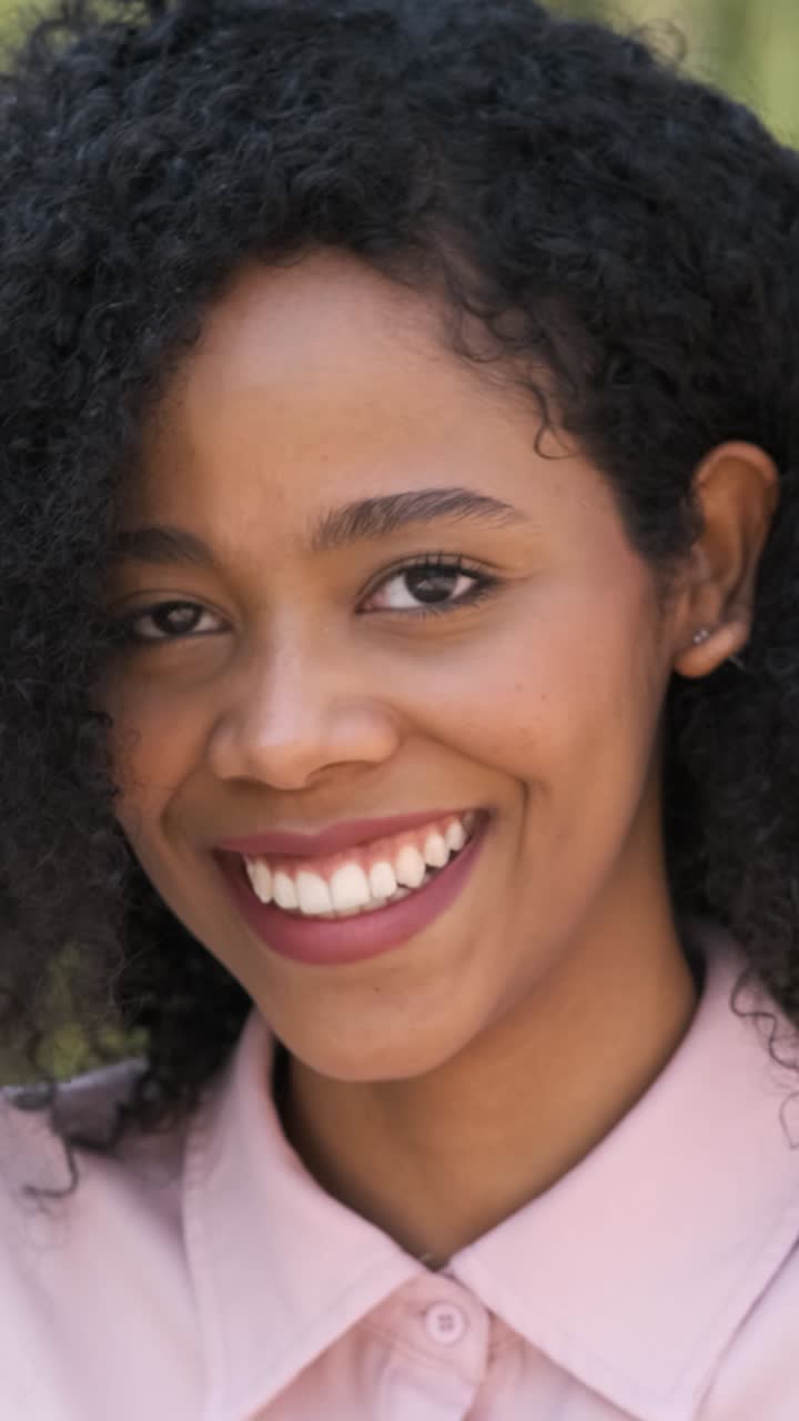 Contented black woman smiling in city during daytime