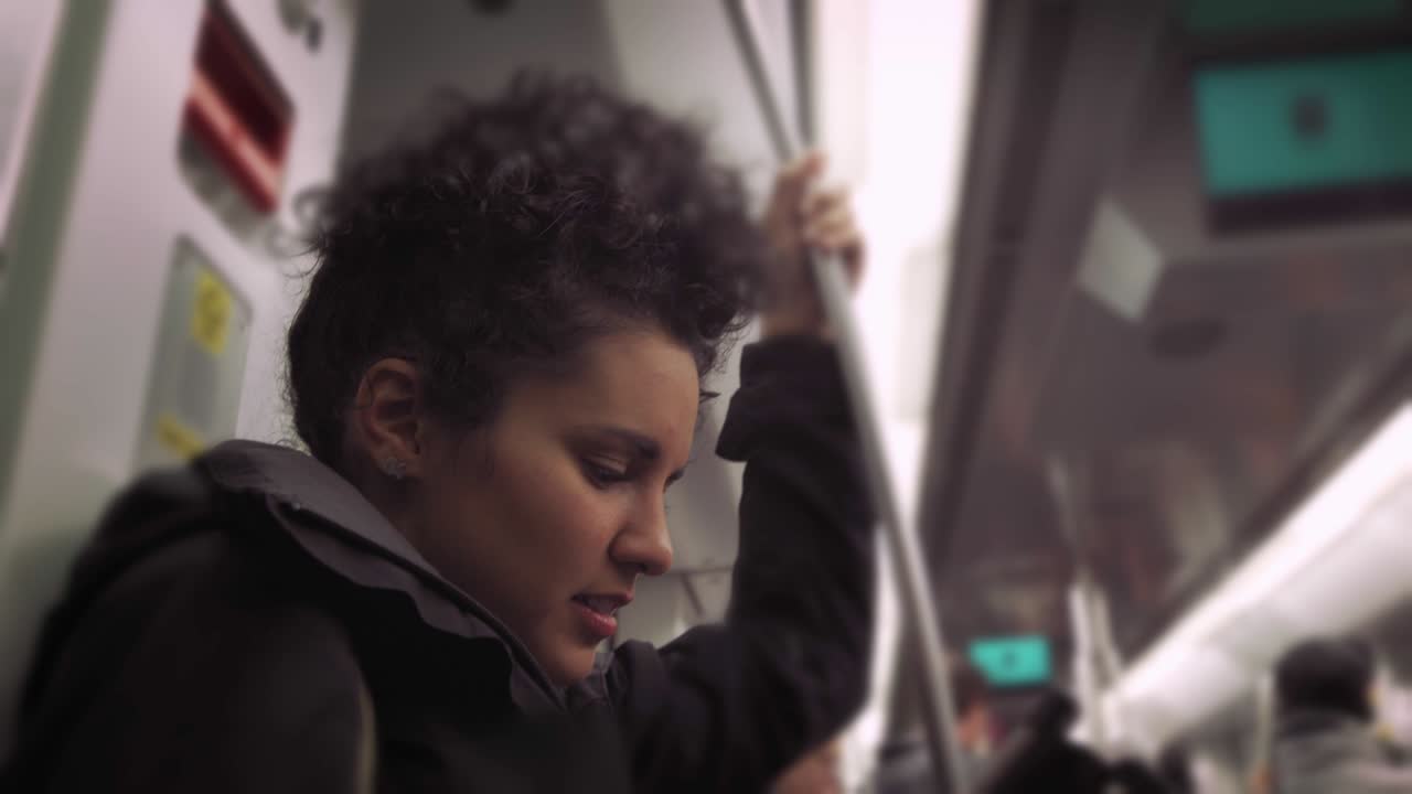 기차 나 지하철 에서 여행 하는 동안 휴대 전화 를 사용하는 히스패닉 젊은 여자