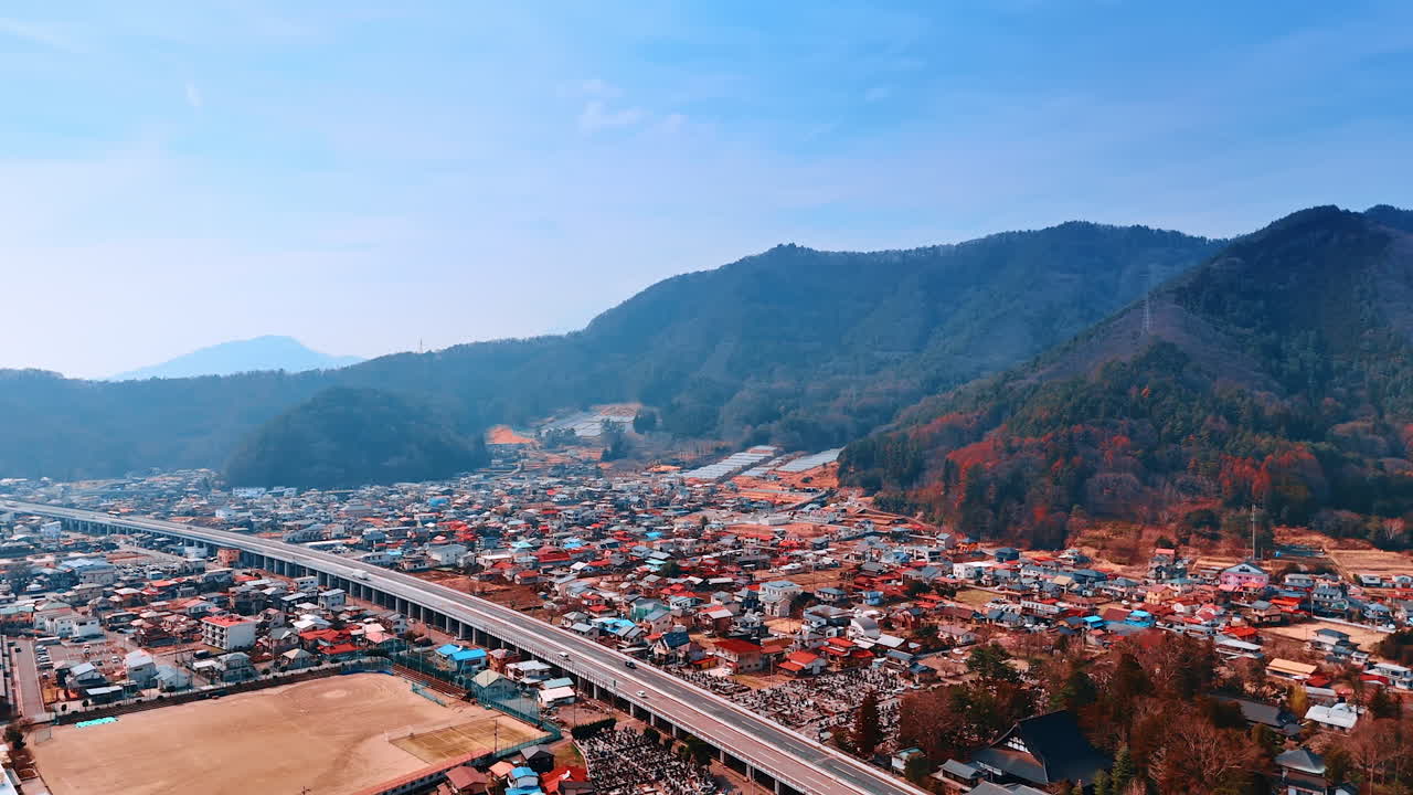 Long freeway crossing the highly populated area. Cityscape at the foot of the Mount Fuji, Honshu, Japan. Aerial view.