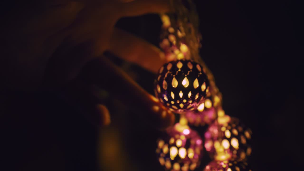 랜턴의 마법의 뜨거운 빛은 여자의 눈에 떨어집니다. 벌거벗은 성인 섹시한 백인 소녀는 밤에 침대에 누워서 손에 따뜻한 램프를 들고 있습니다.