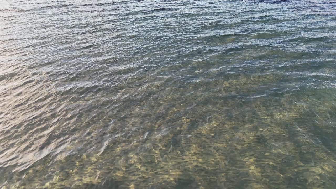 Calm sea waves gently meet a wooden breakwater at a coastal location in Victoria, Australia