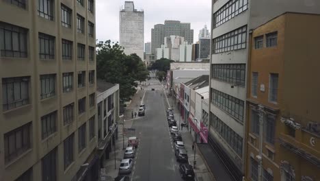 aerial footage between big buildings and empty streets