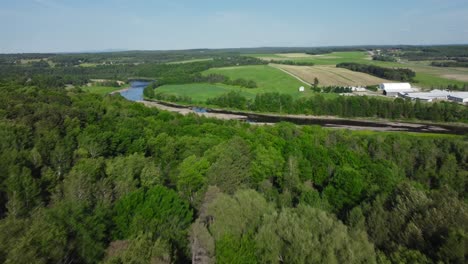 Green-Land-Aerial-Reveal-of-River-in-Rural-Farmland-Town