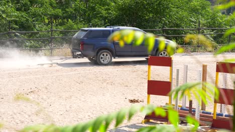 utility vehicle with an arena drag drives around obstacles to smooth the footing. rack focus