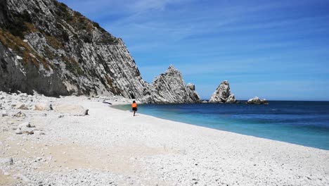 playa de las dos hermanas de numana con guijarros de colores y olas