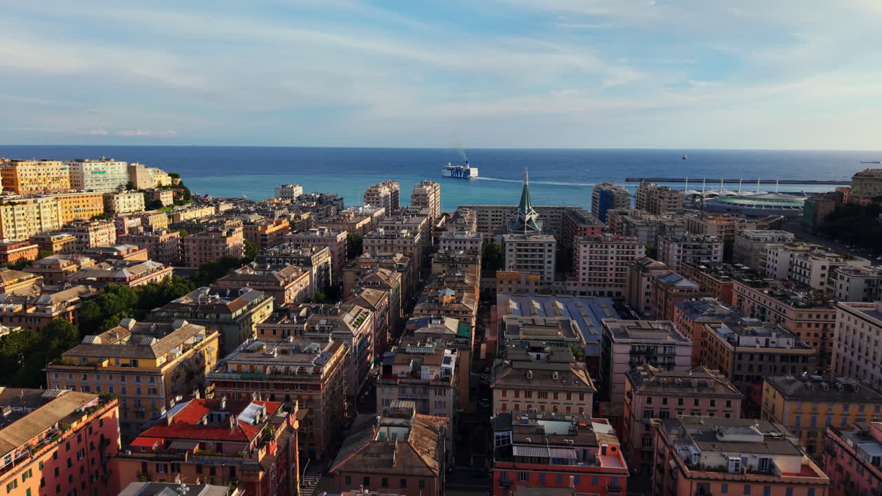 Drone shot moving forward over colorful Genoa old town rooftops, heading towards the sea where a ferry sails away