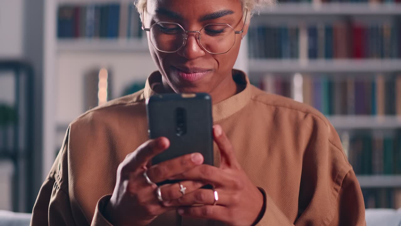 Cheerful african american woman mobile phone typing message and smile
