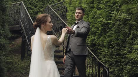 Newlyweds,-caucasian-groom-with-bride-stay-on-stairs-in-park,-wedding-couple,-man-and-woman-in-love