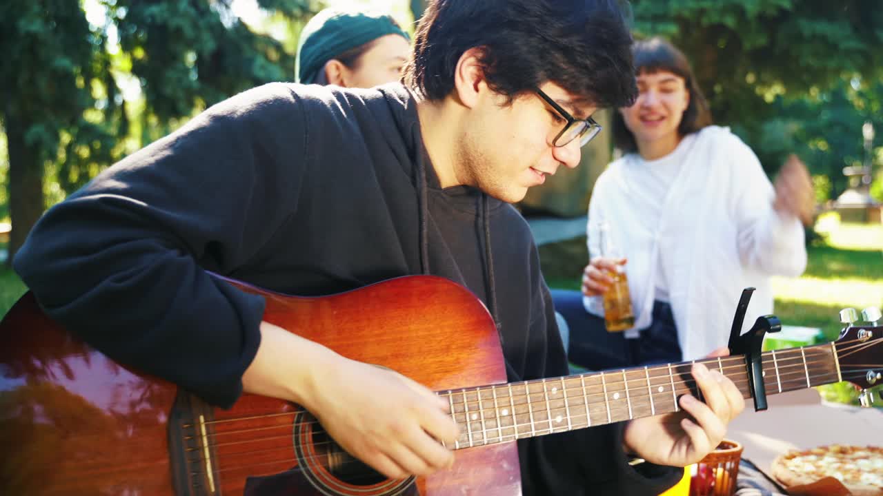 친구 들 이 음악 과 함께 공원 에서 피크닉 을 즐기고 있다