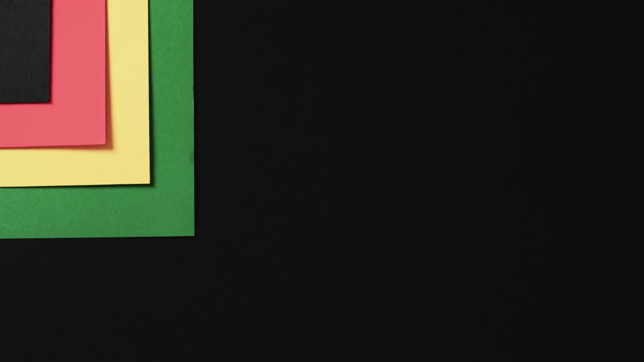 vídeo de papeles rojos, amarillos y verdes con espacio de copia en fondo negro