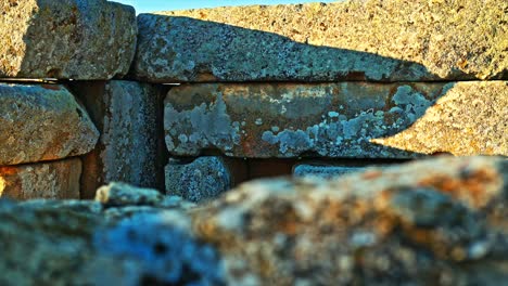 vista en primer plano de antiguos bloques de piedra calentándose bajo la cálida luz del sol, mostrando la textura y la erosión de la estructura histórica