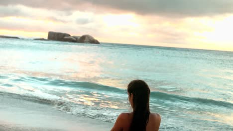 mujer realizando yoga en la playa