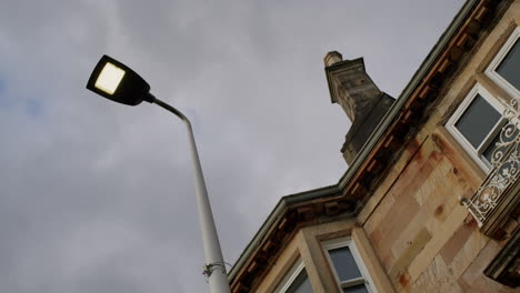 streetlamp and stone house low angle with cloudy sky