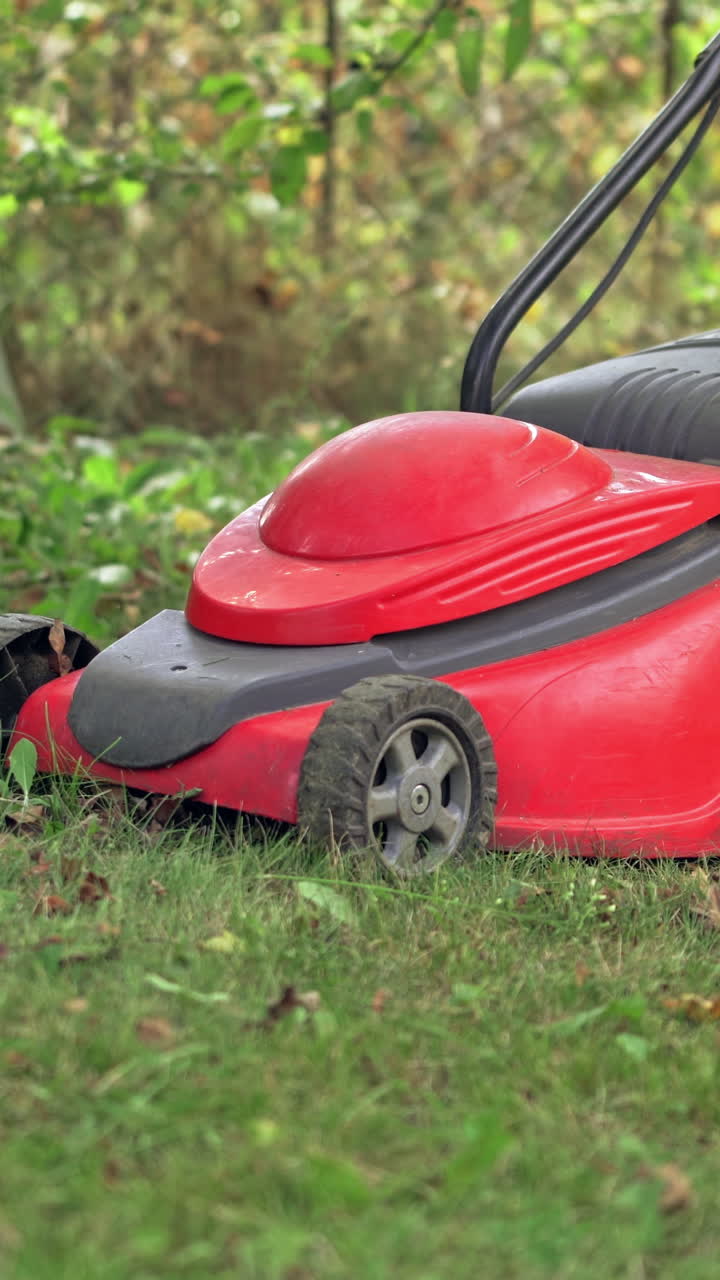 Powerful red lawn mower. Vertical video