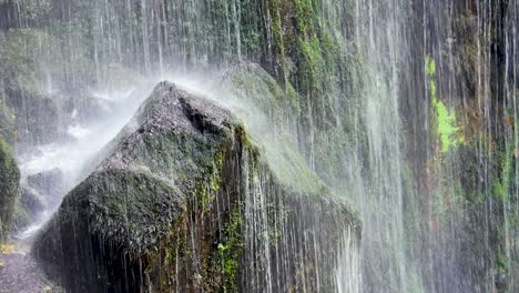 el agua de la cascada de aguacaida en galicia gotea sobre rocas musgosas, en pantón, lugo, españa